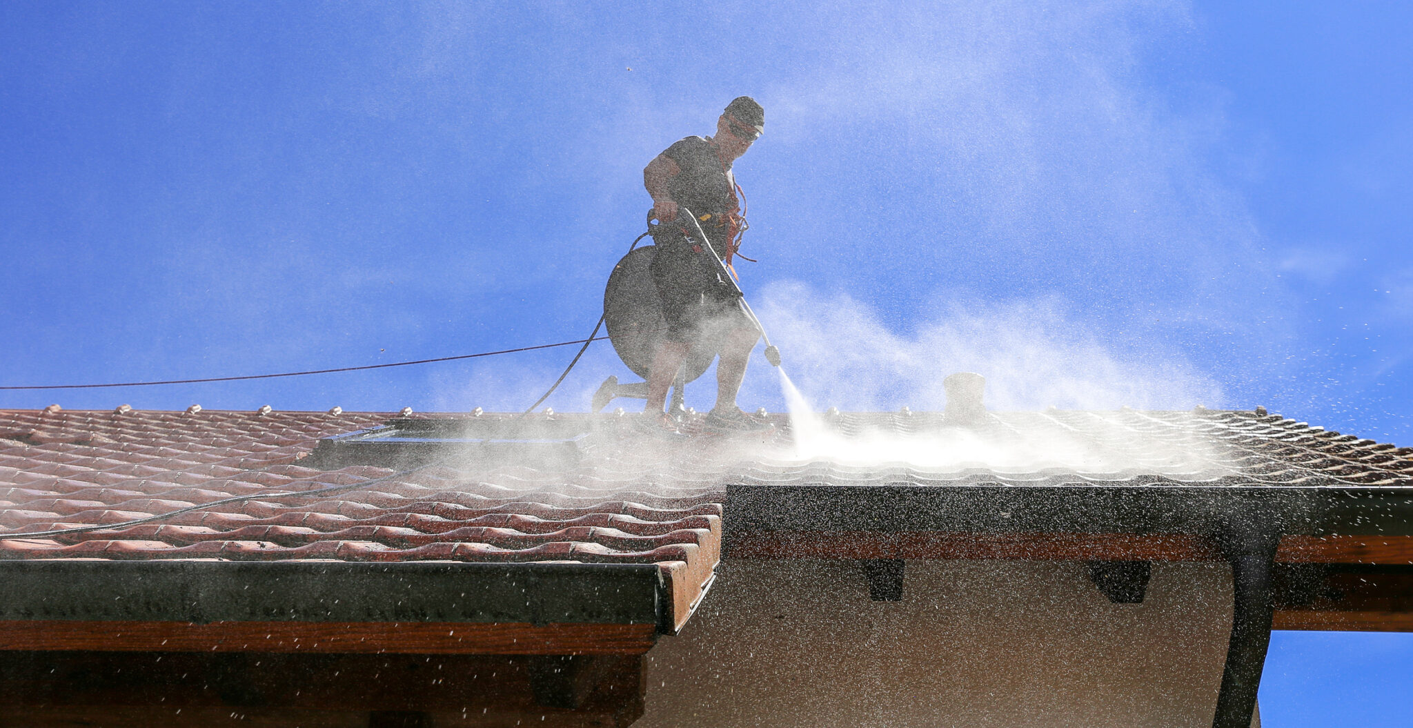 Man cleaning the roof with high pressure